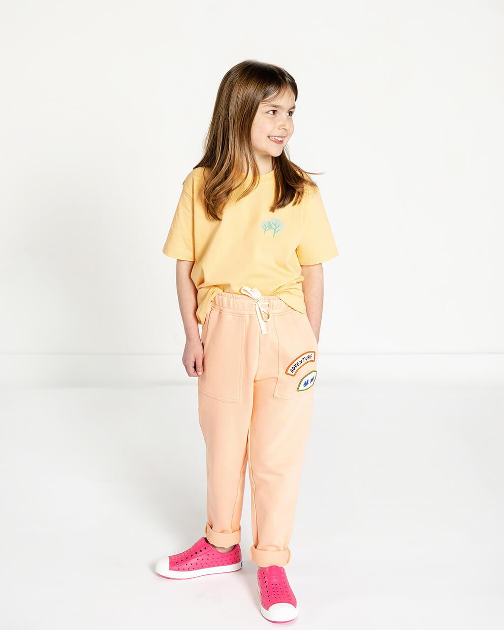 Girls blouse and yellow trousers. Teen girl white cotton shirt, colored  pants on white wooden background. Young lady boutique apparel Stock Photo -  Alamy